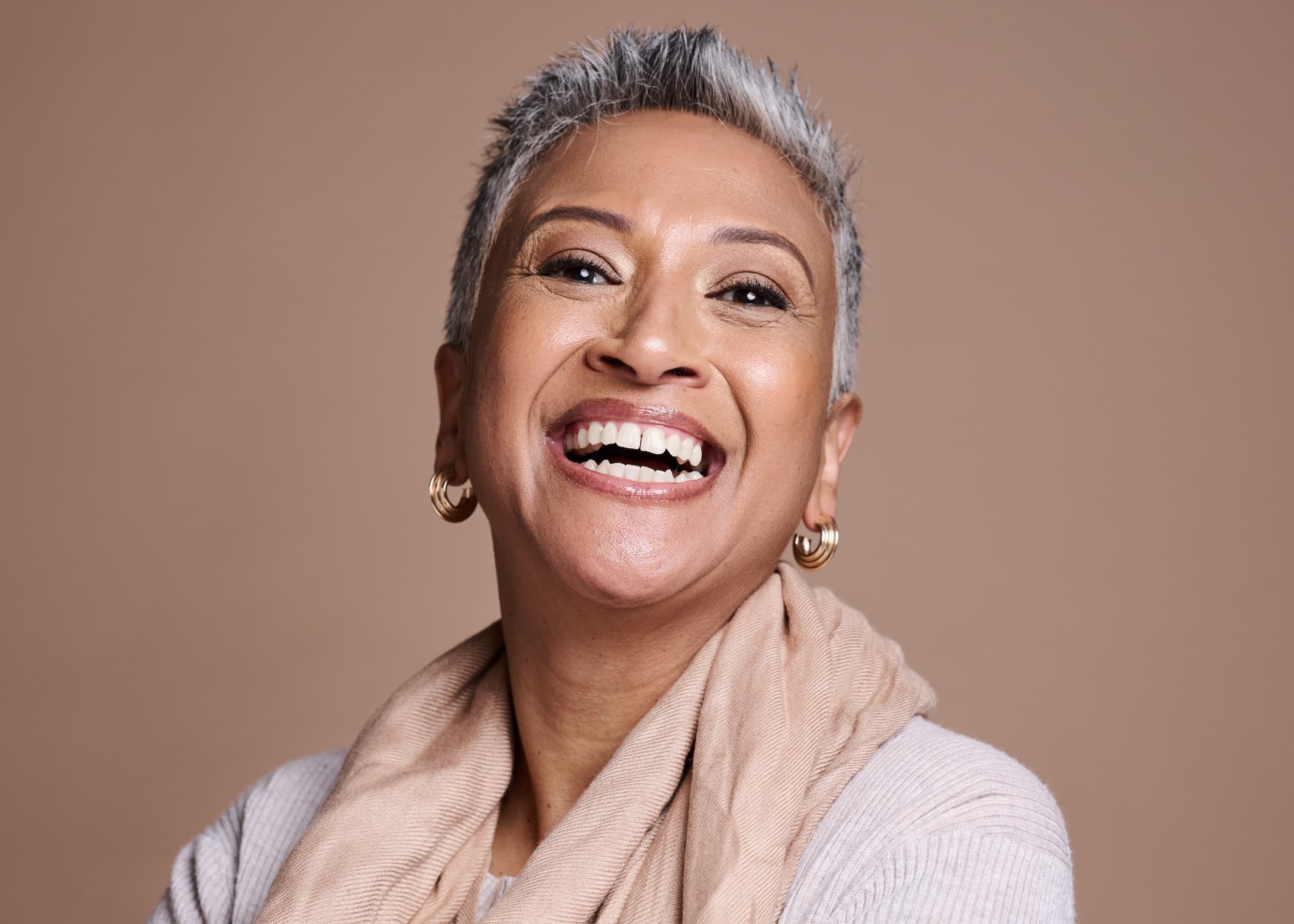 Confident mature woman laughing after cosmetic dentistry transformation at Esthetique Dentistry Ashburn VA
